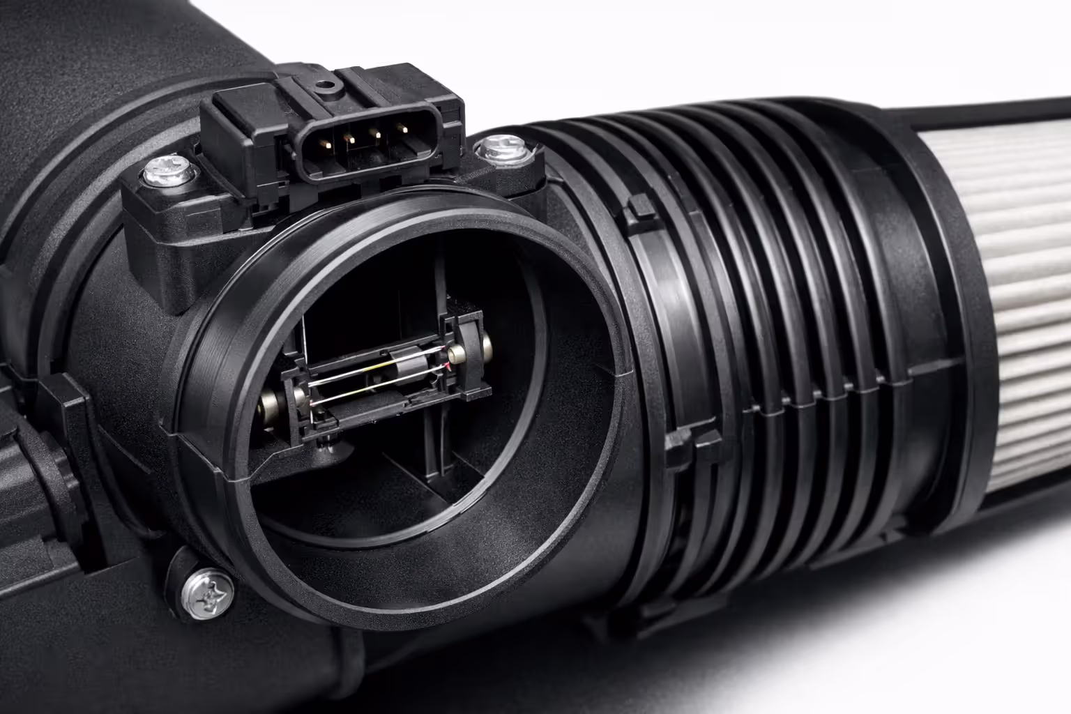 Close-up of a mass airflow MAF sensor mounted inside an engine intake air duct showing the thin heated sensing wire element